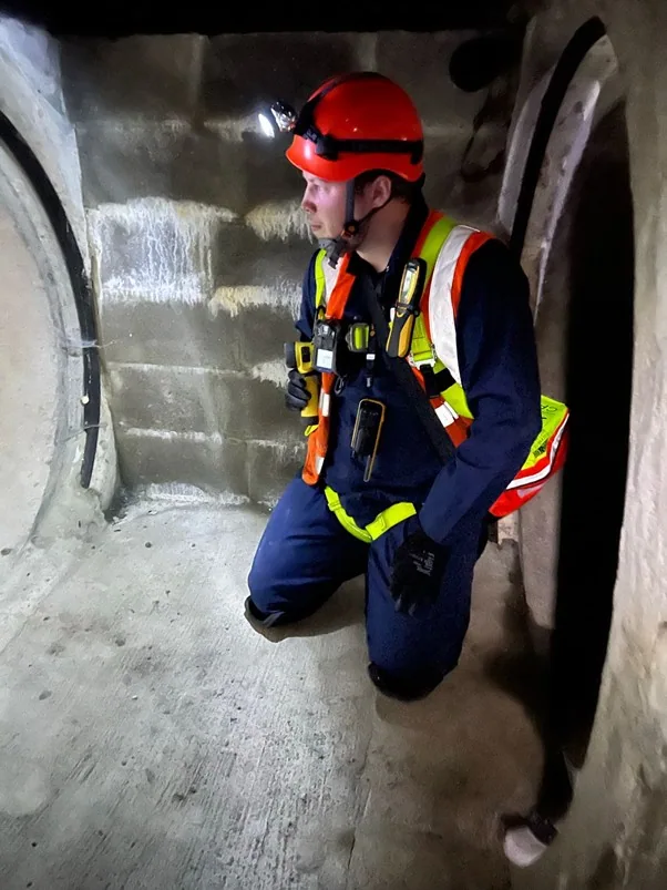 Worker wearing protective equipment entering a confined environment
