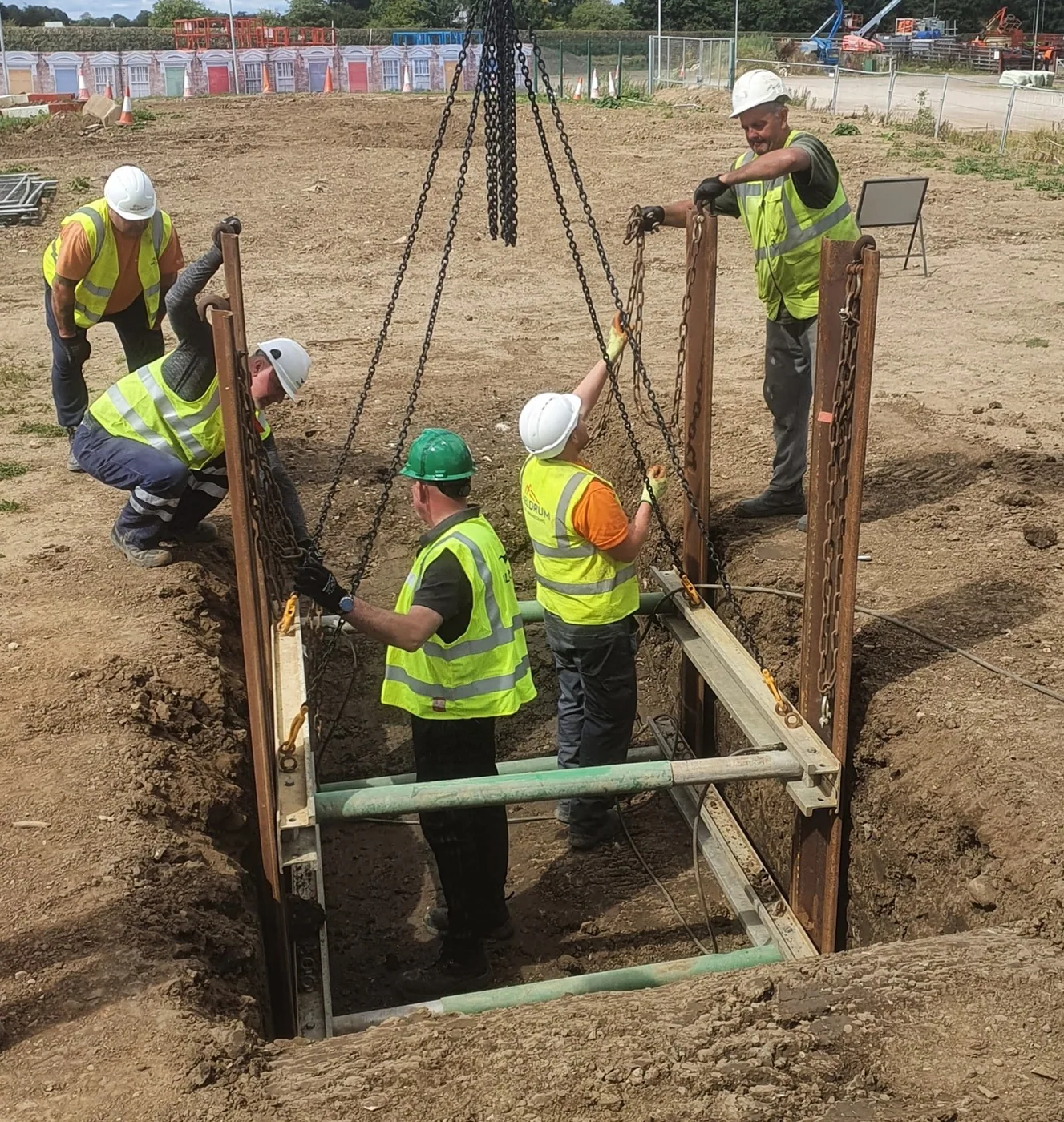 Trainees working within a supported excavation with installation equipment